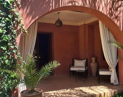 an archway in a room with a chair and a plant at Villa Sophia in Azib Oulad Lâdem