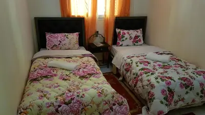 two beds sitting next to each other in a room at Hotel Nice 06 in Midelt