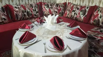 a table with red napkins and plates on a couch at Hotel Nice 06 in Midelt