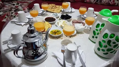 a table with a breakfast of orange juice and food at Hotel Nice 06 in Midelt
