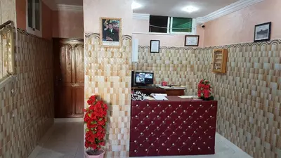 a lobby with a cash register and flowers on the wall at Hotel Nice 06 in Midelt