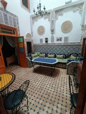 a room with a couch and a table and chairs at Riad lala Drissia in Gare de Tanger-Fès