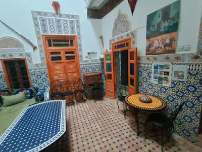 a room with blue and white tiled walls and a table at Riad lala Drissia in Gare de Tanger-Fès