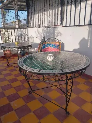 a table in a room with a chair and a table at Riad lala Drissia in Gare de Tanger-Fès