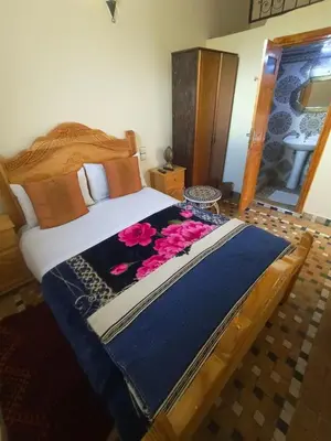 a bedroom with a large bed with flowers on it at Riad lala Drissia in Gare de Tanger-Fès