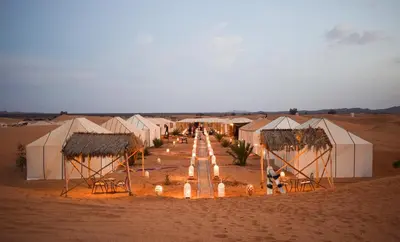 a row of white tents in the desert at Africa Luxury Camps - Merzouga Premium Camp in Merzouga