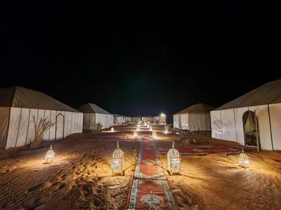 a group of lights on a dirt road at night at Africa Luxury Camps - Merzouga Premium Camp in Merzouga
