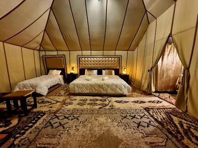 a bedroom with two beds in a tent at Africa Luxury Camps - Merzouga Premium Camp in Merzouga