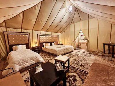 a bedroom with two beds in a tent at Africa Luxury Camps - Merzouga Premium Camp in Merzouga
