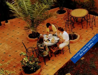 a group of people sitting around a table eating food at Riad Fennec Sahara in Zagora