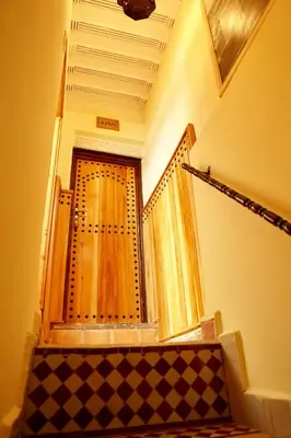 a staircase with a wooden door in a building at Dar Belmamoun in Fès