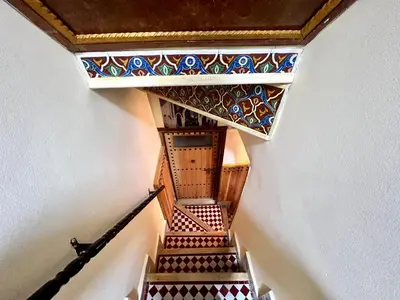 a stairway with a mosaic design on the wall at Dar Belmamoun in Fès