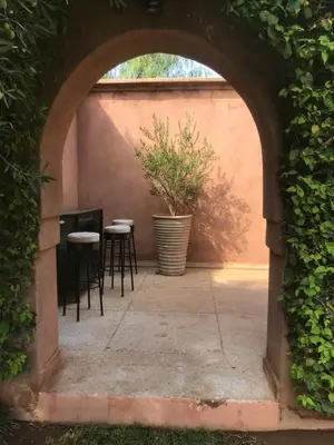 an archway with chairs and a potted plant on a patio at Villa #1 ‘Rosalie’ in Marrakech