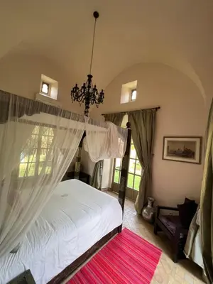 a bedroom with a white bed and a chandelier at Villa #1 ‘Rosalie’ in Marrakech
