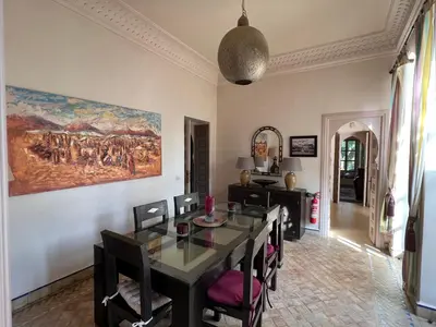 a dining room with a table and a painting on the wall at Villa #1 ‘Rosalie’ in Marrakech