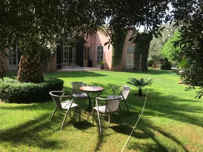 a table and chairs in the yard of a house at Villa #1 ‘Rosalie’ in Marrakech
