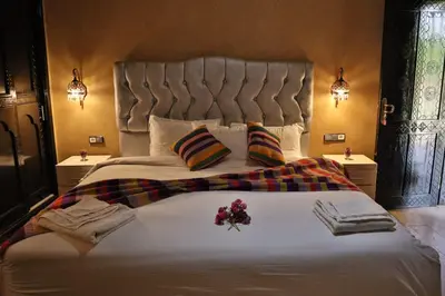 a bedroom with a large bed with flowers on it at Residence Touristique Merzouga in Merzouga