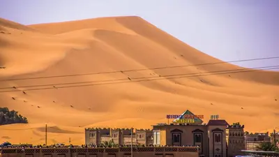 a view of a desert with a large sand mound at Residence Touristique Merzouga in Merzouga