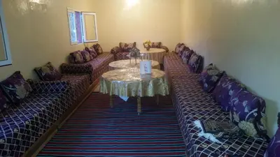 a room with couches and a table and a table and chairs at Auberge de Tabhirte in Tahla