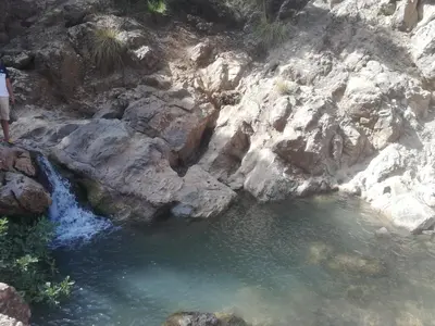 a person standing next to a pool of water at Auberge de Tabhirte in Tahla