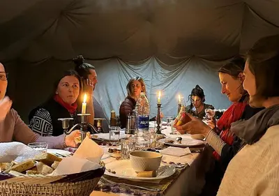 a group of people sitting around a table in a tent at Deep Desert Camp in Merzouga