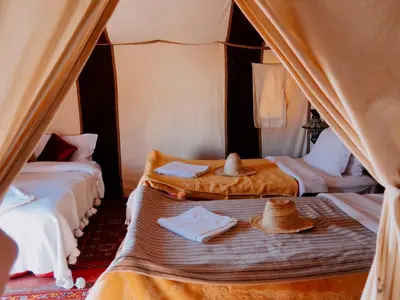 a room with two beds with hats on them at Deep Desert Camp in Merzouga