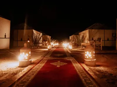a street at night with lights on the road at Deep Desert Camp in Merzouga