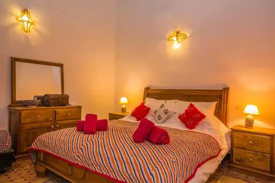 a bedroom with a bed with red pillows on it at Riad Zina Fes - Elegance in the Heart of Fes in Fès