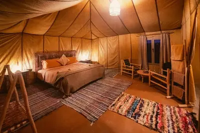 a bedroom with a bed in a tent at Auberge Bivouac La Belle Etoile in Merzouga