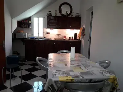 a kitchen with a table with chairs and a counter top at BELLE MAISON AU COEUR DES MONTAGNES DE TAZA à moins de 10 minutes de l'AGORA PARK in Taza