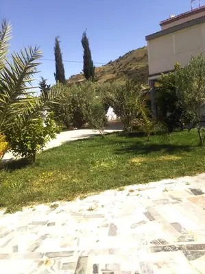 a yard with a house and grass and trees at BELLE MAISON AU COEUR DES MONTAGNES DE TAZA à moins de 10 minutes de l'AGORA PARK in Taza