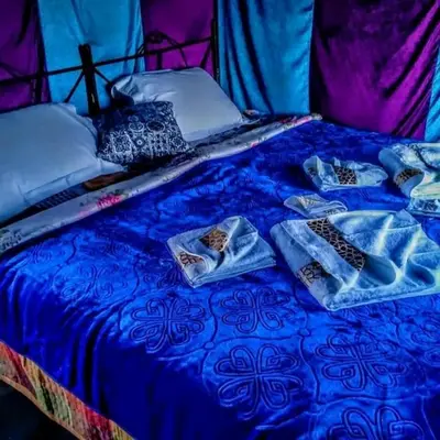 a bed with blue sheets and pillows on it at Chez zakaria luxury camp merzouga in Merzouga
