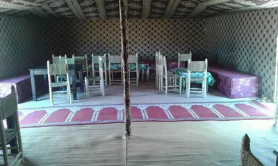 a room with a table and chairs on a stage at Chez zakaria luxury camp merzouga in Merzouga