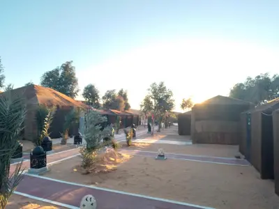 an empty courtyard with trees and a building at Chez zakaria luxury camp merzouga in Merzouga