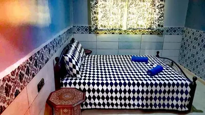 a bedroom with a black and white bed with a window at Adam's House-moroccan style in Fès
