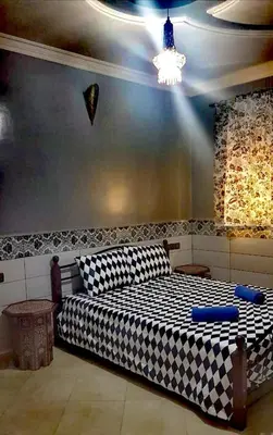 a bedroom with a checkered bed in a room at Adam's House-moroccan style in Fès