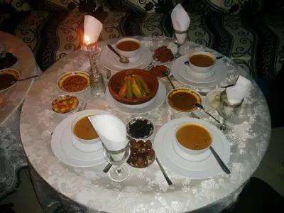 a table with bowls of soup and plates of food at Riad El Bacha in Fès