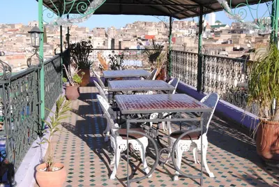 a row of tables and chairs on a balcony at Riad El Bacha in Fès