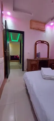 a bedroom with a bed and a doorway with a green light at حدائق إفران in Ifrane