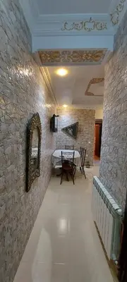 a dining room with a table and a stone wall at حدائق إفران in Ifrane