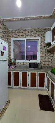 a kitchen with a white refrigerator and a window at حدائق إفران in Ifrane