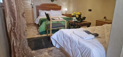 a bedroom with a bed and a desk with a chair at Bio Palace Hotel in Tinerhir