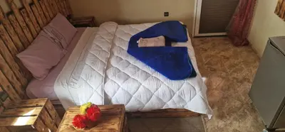 a bedroom with a white bed with blue sheets at Bio Palace Hotel in Tinerhir