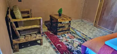 a bedroom with a bed and a chair and a table at Bio Palace Hotel in Tinerhir