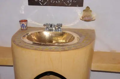 a bathroom with a sink on a wooden counter at Ksar Jenna in Nkob