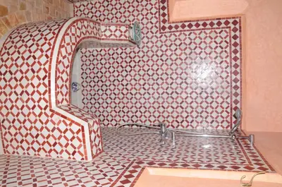 a bathroom with a shower with a tiled floor at Ksar Jenna in Nkob