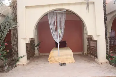 a bed in an archway on a patio at Ksar Jenna in Nkob