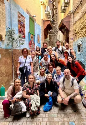 a group of people posing for a picture in an alley at Riad Le Petit Patrimoine De Fés in Fès