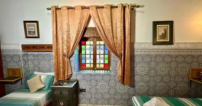 a room with two beds and a window at Riad Le Petit Patrimoine De Fés in Fès