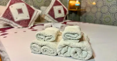 a pile of towels sitting on top of a bed at Riad Le Petit Patrimoine De Fés in Fès